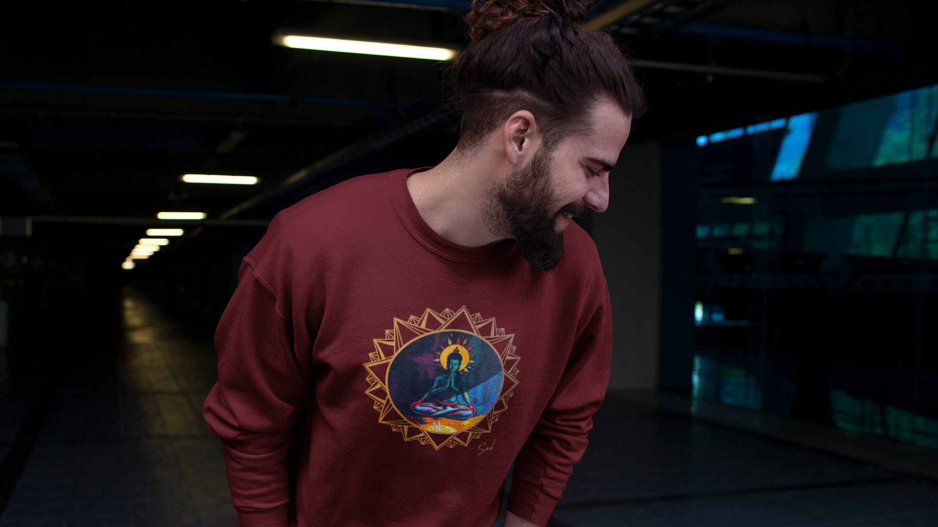 Man wearing a red sweatshirt with the graphic design "Krishna" by Soul Art in a dark indoor setting