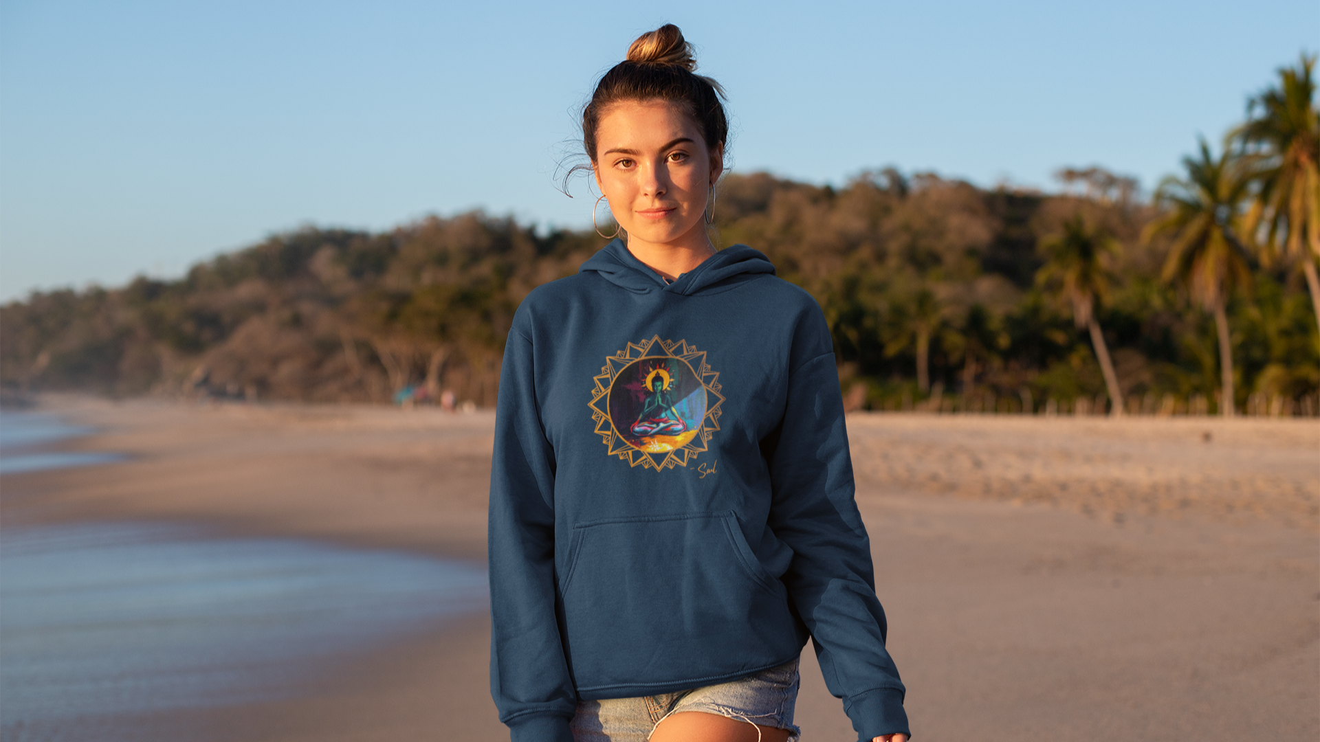 Sexy Woman wearing a blue hoodie with the Soul Art graphic design on a beach by the Ocean