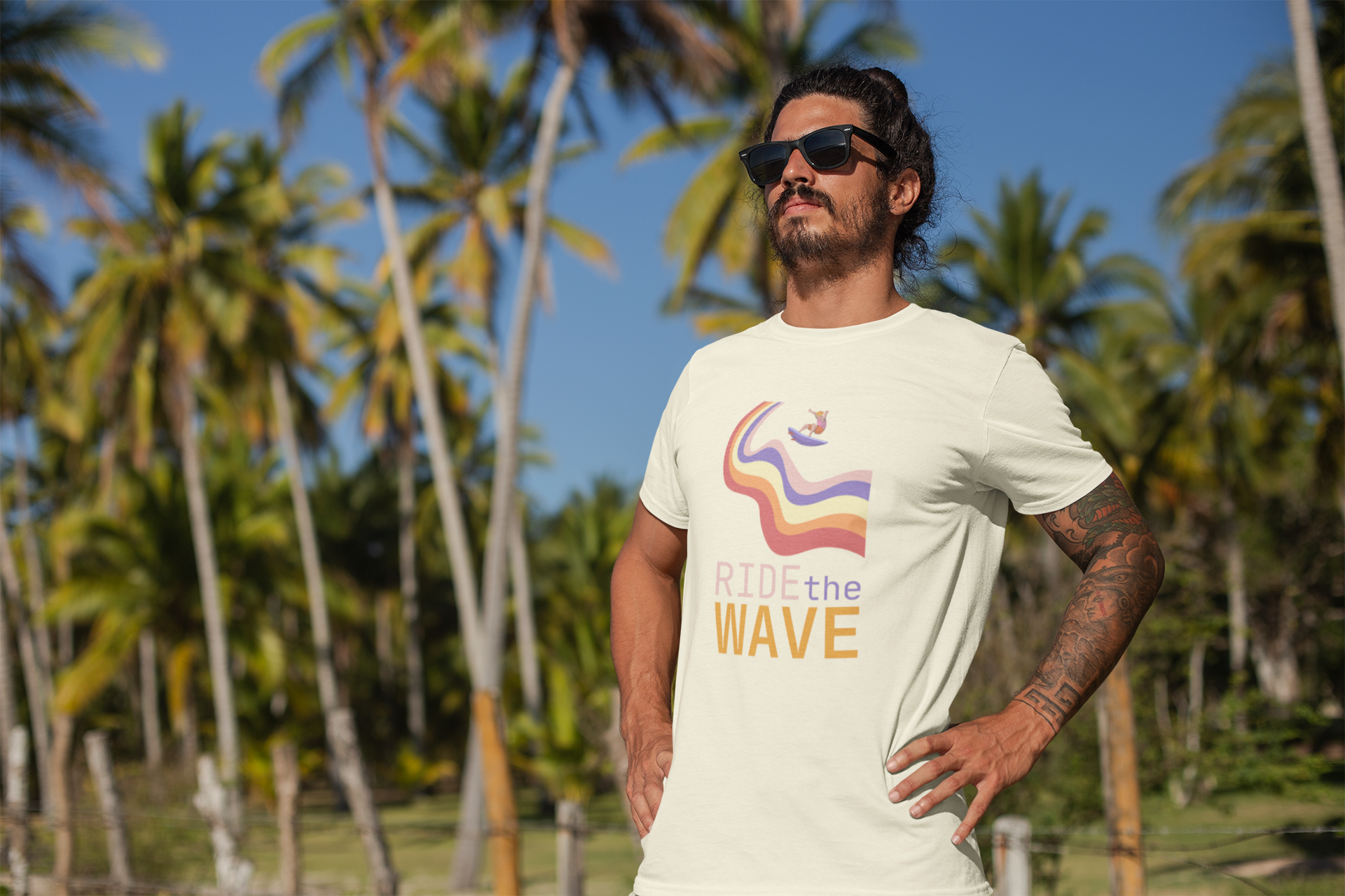 Surfer Man with long hair wearing a t-shirt with the Soul Art 'Ride the Wave' design in a tropical setting